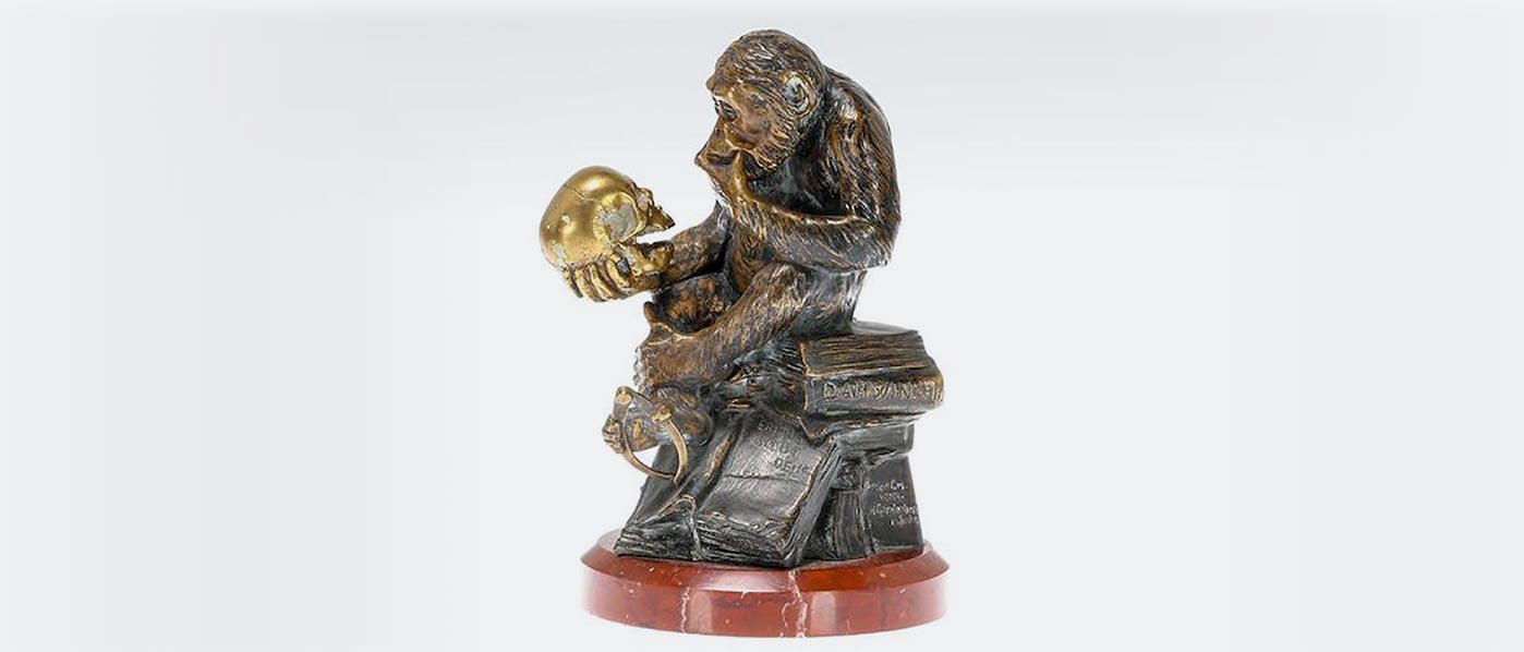 Statue of a monkey holding a skull
