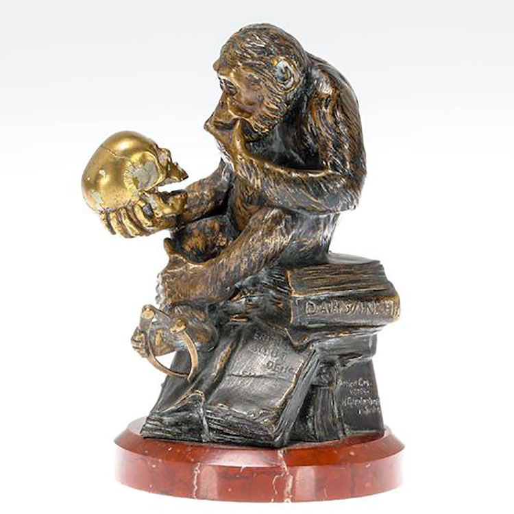 Statue of a monkey holding a skull